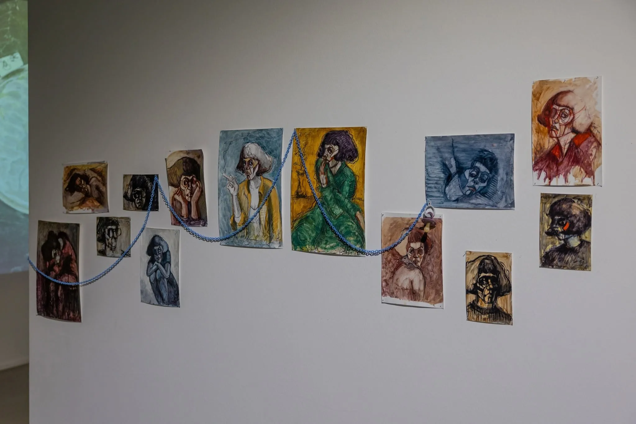 Chinara Chi's works hung in a rising line, joined by a blue cord