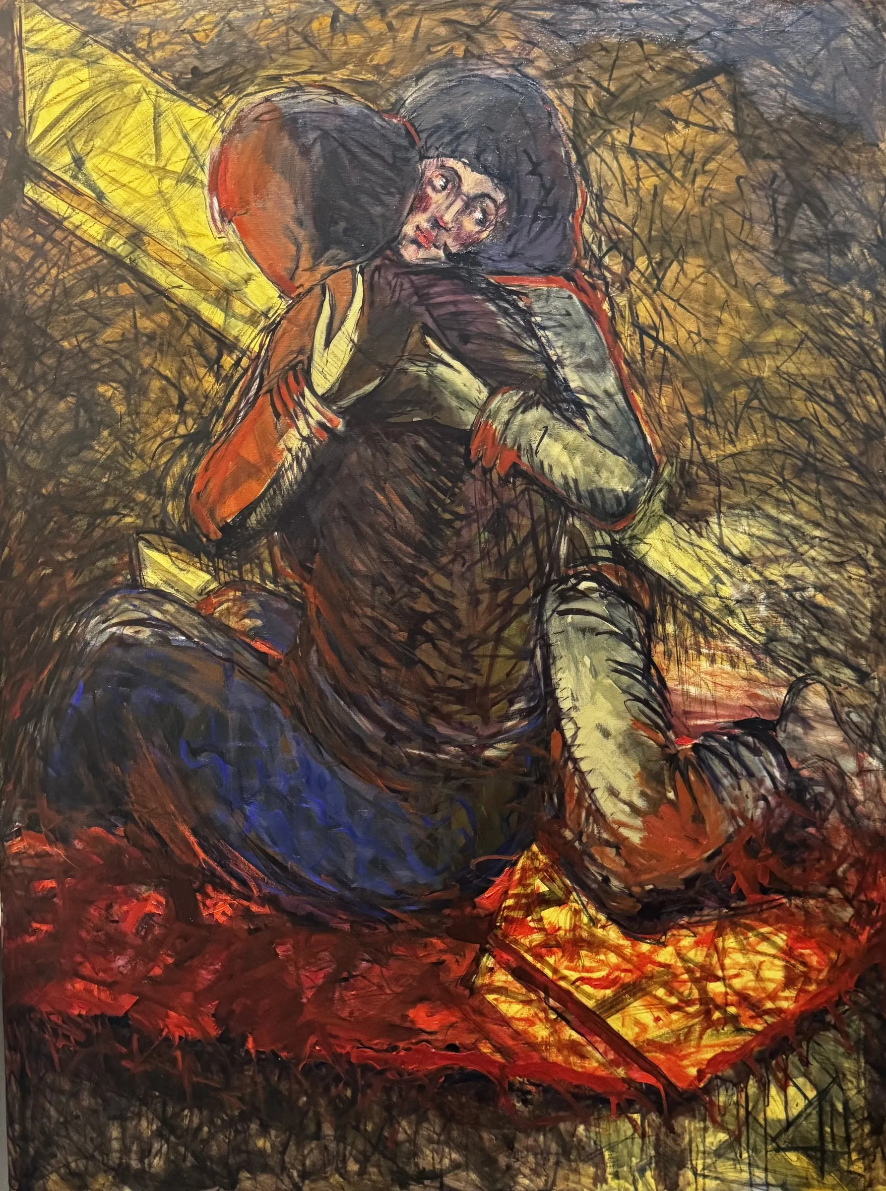 Seated figure in yellow and red, built from angular strokes